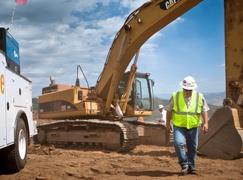 Man walking in front of excavator