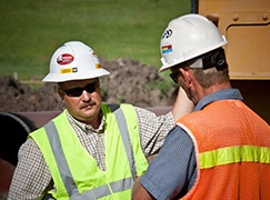 Men talking wearing safety gear